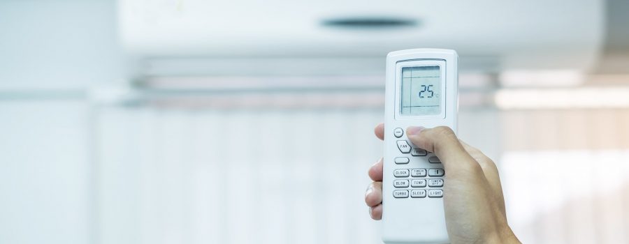 hand using remote controller for adjust Air conditioner